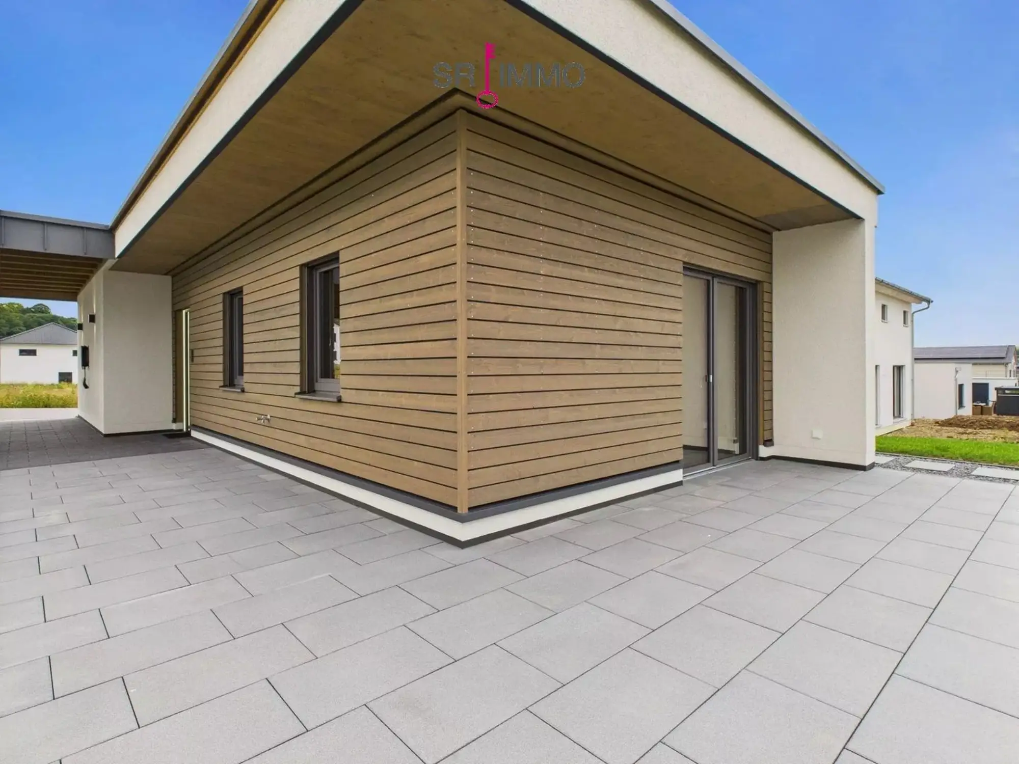 Holzhaus mit weit auskragendem Dach und großer Terrasse in Welschbillig